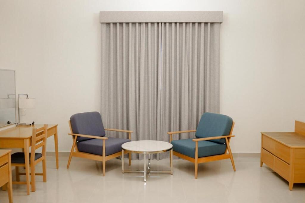 Seating area and work desk inside a room at Assia Hotel